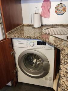 - un lave-linge dans la cuisine sous un comptoir dans l'établissement Alto Las Condes - A pasos del Mall - Excelente y cómodo Departamento p/2 personas, à Santiago