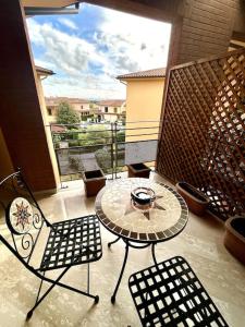 eine Terrasse mit einem Tisch und Stühlen auf dem Balkon in der Unterkunft La Casa nel Verde in Pistoia