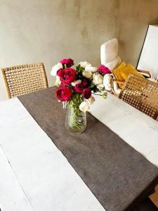 eine Vase voller roter und weißer Blumen auf dem Tisch in der Unterkunft La Casa nel Verde in Pistoia