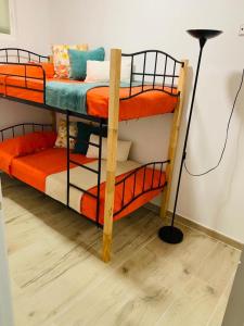 two bunk beds in a room with a lamp at Bien comunicado, acogedor y confortable in Coslada