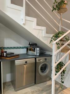 una lavatrice e un'asciugatrice in una cucina sotto una scala di Bien comunicado, acogedor y confortable a Coslada