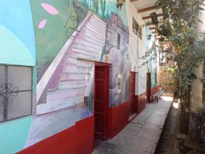 un mural en el lateral de un edificio con una puerta roja en DEJAVU en Chachapoyas