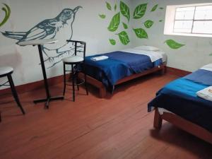 1 dormitorio con 2 camas y un pájaro en la pared en DEJAVU en Chachapoyas