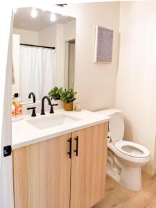 a bathroom with a sink and a toilet at Brand New Modern Apartment in Vancouver