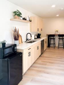 a kitchen with a black refrigerator and a sink at Brand New Modern Apartment in Vancouver
