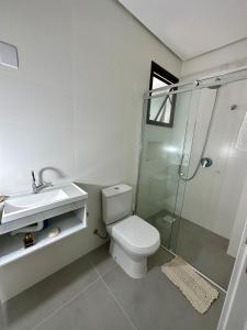 a bathroom with a toilet and a shower and a sink at Conchas das Caravelas in Governador Celso Ramos