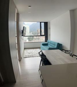 une chambre avec une table, des chaises et une fenêtre dans l'établissement Apartamentos Centro Bogotá piso 16 y o piso 23 -Vista Monserrate, à Bogotá