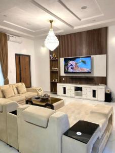 a living room with a couch and a tv at Urban Retreat Luxury Shortlet Apartment Lekki Lagos in Lekki