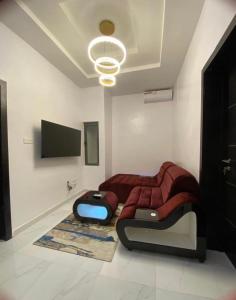 - une chambre avec un lit et une télévision à écran plat dans l'établissement Urban Retreat Luxury Shortlet Apartment Lekki Lagos, à Lekki