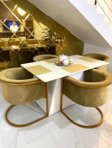 a table with two chairs and a table with a plate on it at Urban Retreat Luxury Shortlet Apartment Lekki Lagos in Lekki