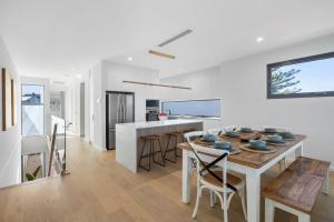 a kitchen and dining room with a table and chairs at Driftwood Port Noarlunga South in Port Noarlunga South