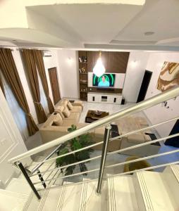 a staircase in a living room with a couch and a tv at Urban Retreat Luxury Shortlet Apartment Lekki Lagos in Lekki