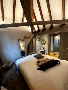 a bedroom with a large white bed with wooden ceilings at Ferme Marie Hélène in Ittlenheim