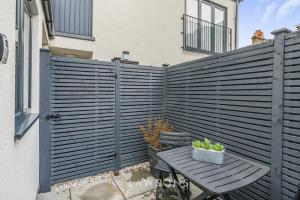 una valla de madera junto a una mesa con una maceta en Central Living by Lawsons, en Windsor