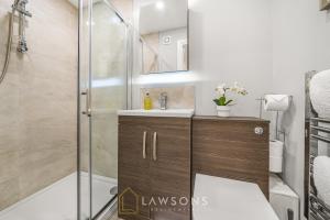 ein Bad mit einer Dusche und einem Waschbecken in der Unterkunft Central Living by Lawsons in Windsor