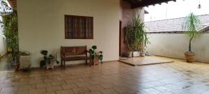 a living room with a chair and potted plants at Recanto do Bem-Te-Vi in Olímpia
