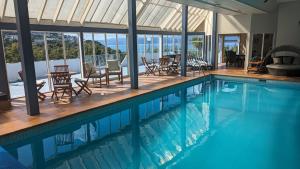 uma piscina com cadeiras e mesas numa casa em Harbour Lodge Wellington em Wellington