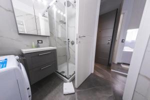 een badkamer met een glazen douche en een wastafel bij Residenza Gioiello - Comfort & Suites a Milano in Milaan