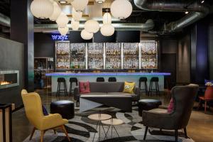 a lobby with a bar with chairs and a couch at Aloft Denver Downtown in Denver