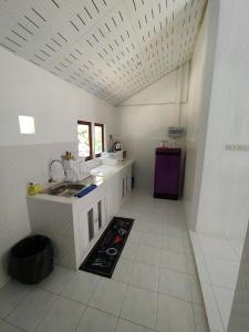 a white kitchen with a sink and a counter at Kood Life in Ko Kood