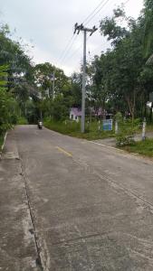 an empty road with a car driving down the street at Kood Life in Ko Kood