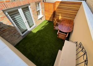 a small patio with a table and chairs on a lawn at The Eagles in Kent