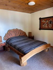 a wooden bed in a bedroom with a wooden ceiling at HARRIS HOTEL Y RESTAURANTE in Licán Ray
