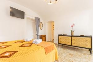 a bedroom with a yellow bed and a dresser at Extravacanza Central Station 2 in Bari