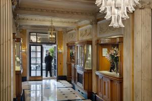 Un homme se promène dans un couloir avec un lustre. dans l'établissement Grand Residences by Marriott - Mayfair-London, à Londres