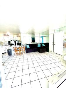 a kitchen and living room with a white tiled floor at Beach Happy - Ocean View at Symphony Beach Club in Ormond Beach