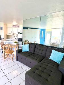 a living room with a couch and a kitchen at Beach Happy - Ocean View at Symphony Beach Club in Ormond Beach