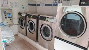 three washing machines are in a laundry room at Les Frangipaniers in Sainte-Luce