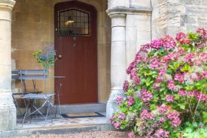 a front door of a house with pink flowers at 2 The Winnings - Stunning Cottage on a Country Estate in Worksop