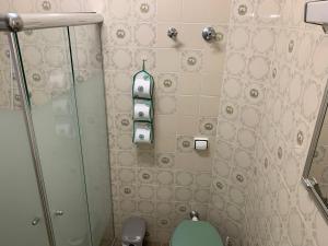 y baño con aseo y ducha acristalada. en Apartamento Vista Mar, en Peruíbe