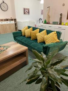 a living room with a green couch with yellow pillows at Veľký apartman in Karlova Ves
