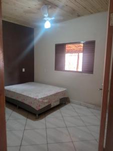 1 dormitorio con cama y ventana en Casa para temporada en Pirenópolis