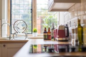a kitchen counter with bottles of wine and a toaster at 2 The Winnings - Stunning Cottage on a Country Estate in Worksop +9 photos