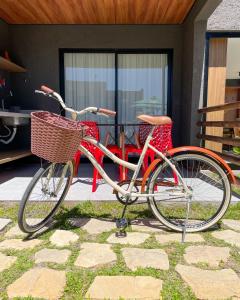 a red bike parked in front of a house at Mani Milagres Studio - Gamboa Patacho in Pôrto de Pedras