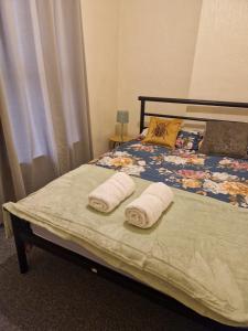 a bedroom with a bed with two towels on it at Tatia House in Gainsborough