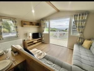 a living room with a couch and a large window at Talland view. Polperro in Looe