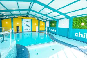 a large swimming pool with a slide in a building at Talland view. Polperro in Looe