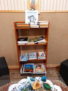 a book shelf with books on it next to a table at Hostal y Cabañas Ventisquero in Puerto Puyuhuapi