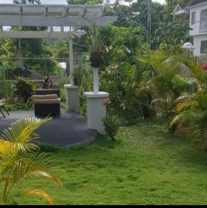 a garden with a person sitting on a bench at Grace Garden Guesthouse in Ocho Rios