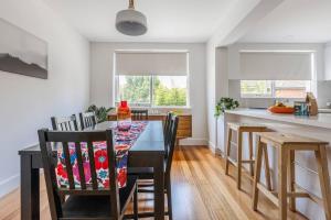 uma cozinha e sala de jantar com mesa e cadeiras em Breezy East - A Light-filled Family Retreat em Melbourne