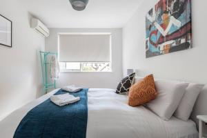uma sala de estar com um sofá branco e uma janela em Breezy East - A Light-filled Family Retreat em Melbourne
