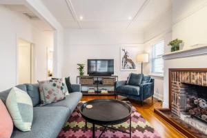 a living room with a couch and a fireplace at Tranquil Inner-east Haven Moments from High Street in Melbourne
