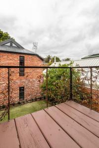 a wooden deck in front of a brick building at Tranquil Inner-east Haven Moments from High Street in Melbourne