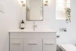 a white bathroom with a sink and a mirror at Tranquil Inner-east Haven Moments from High Street in Melbourne +17 photos