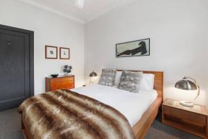 una camera da letto con un letto con una coperta pelosa sopra di Parkside Hideaway - Beautiful Art Deco near Zoo a Melbourne