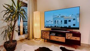 un salon avec une télévision à écran plat et une plante dans l'établissement #PrettyPenthouseEstepona, à Estepona
